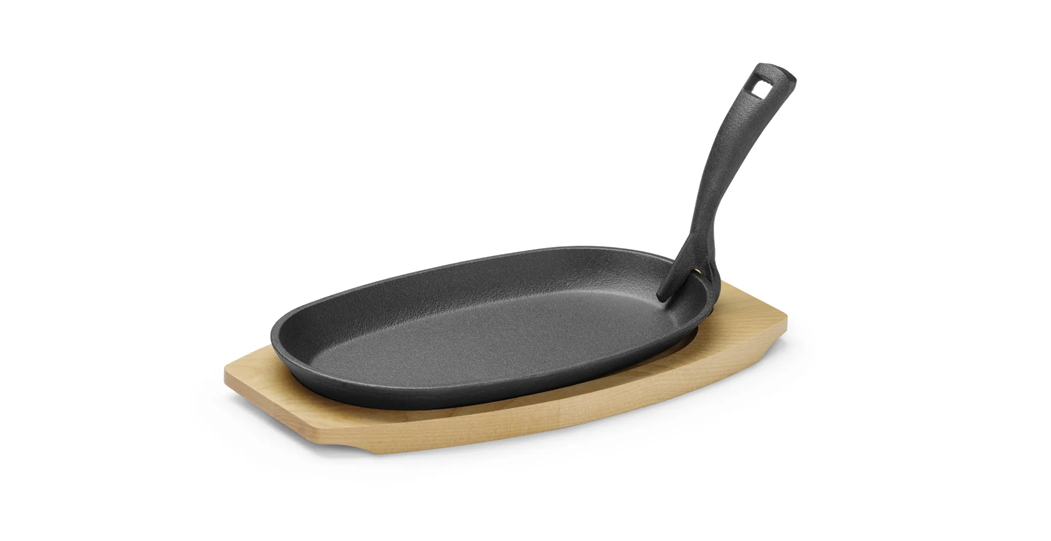 Støpejernspanne med treunderlag og gripetang