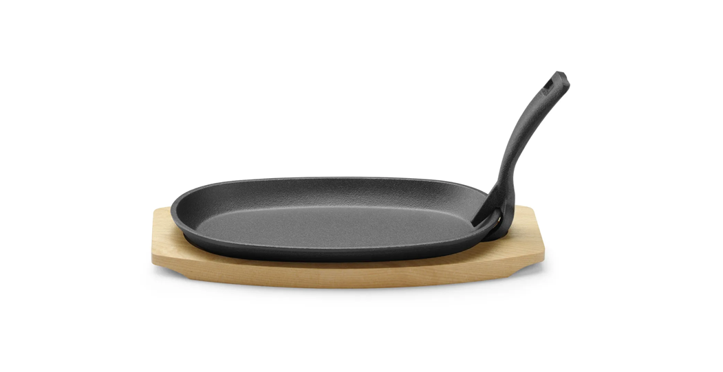 Støpejernspanne med treunderlag og gripetang